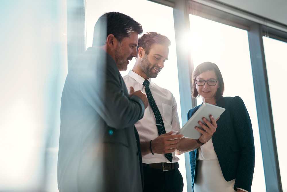 Group,Of,Businesspeople,Using,A,Digital,Tablet,Together,In,Front